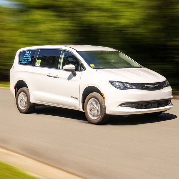 White I&J minivan on the road